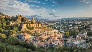 Scenic view of welcoming travel destinations, including Greenland's icebergs, Morocco’s medinas, Serbia’s hills, and Georgia’s cobbled streets.